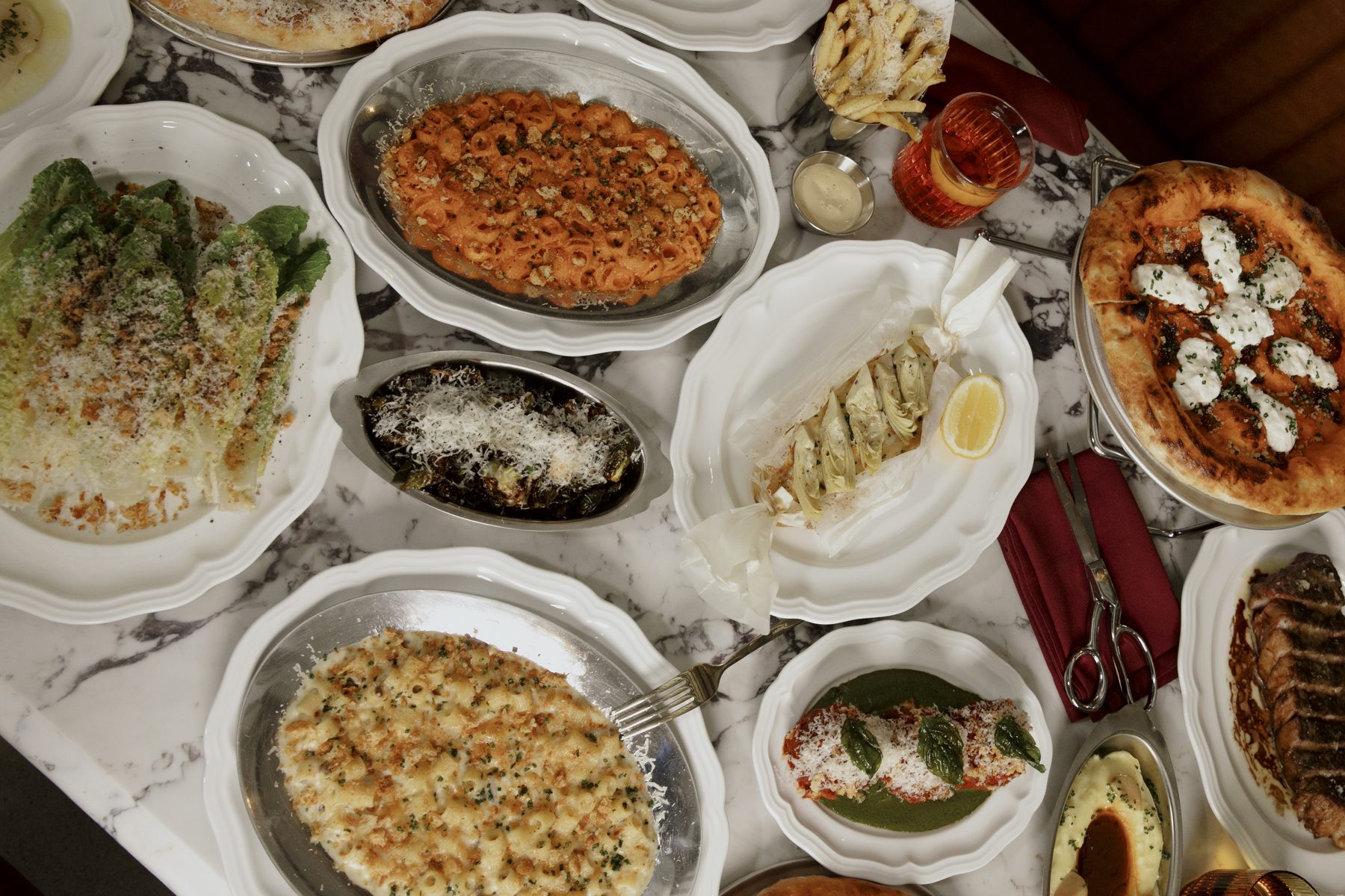 An overhead Salina spread — vodka rigatoni, Caesar, roasted brussels sprouts, eggplant parmesan and pizza
